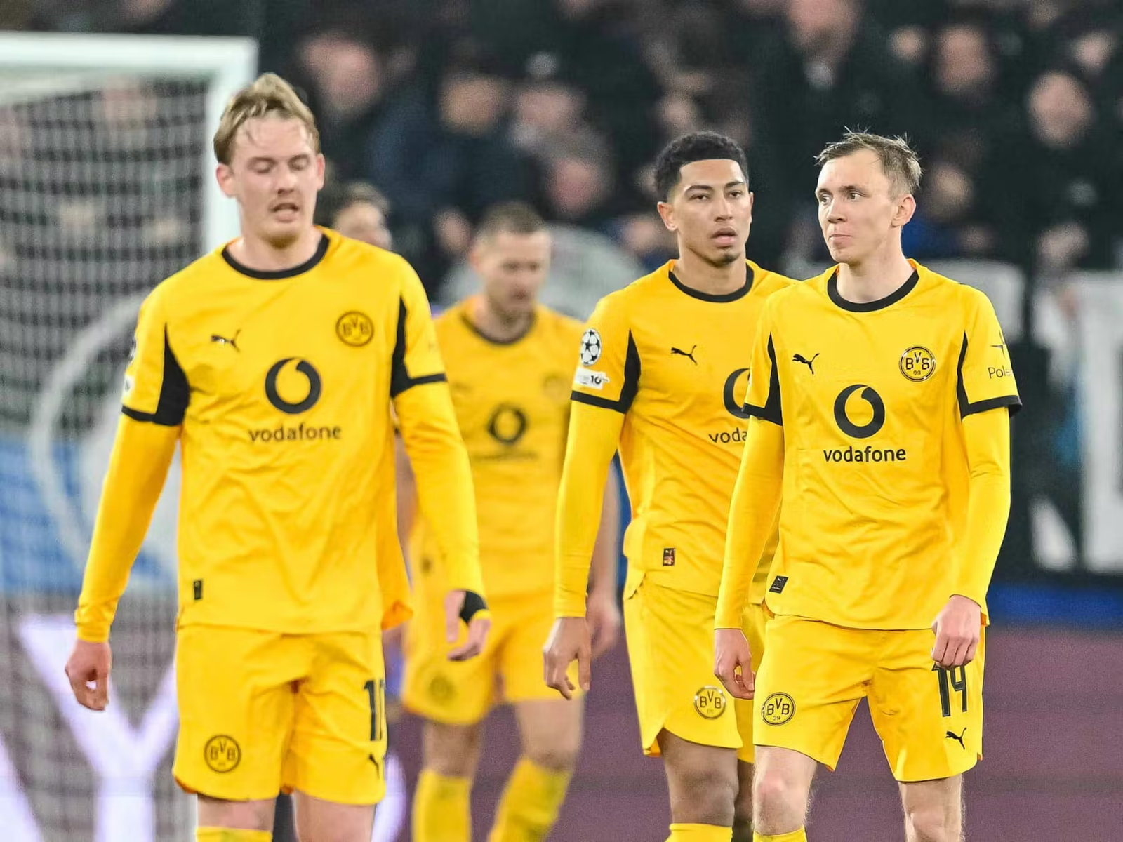 Jugadores del Borussia Dortmund, incluyendo a Jobe Bellingham y Julian Brandt, durante un partido de la UEFA Champions League con la equipación especial amarilla.