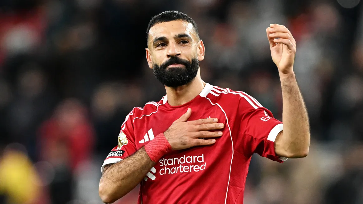 Mohamed Salah celebrando con la camiseta roja del Liverpool FC en Anfield durante un partido de Premier League.