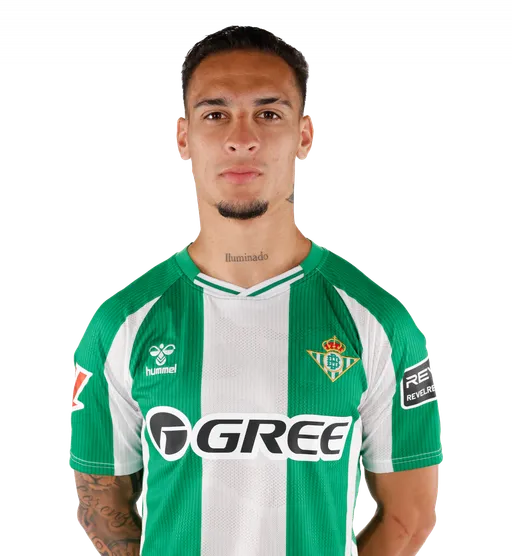 BETIS Retrato frontal de medio cuerpo del jugador Antony con barba de candado y tatuaje con la palabra "Iluminado" en el cuello. Viste la camiseta oficial del Real Betis con franjas verdes y blancas, el escudo del club, la marca Hummel y el patrocinio de GREE. Fondo con cuadrícula de transparencia.