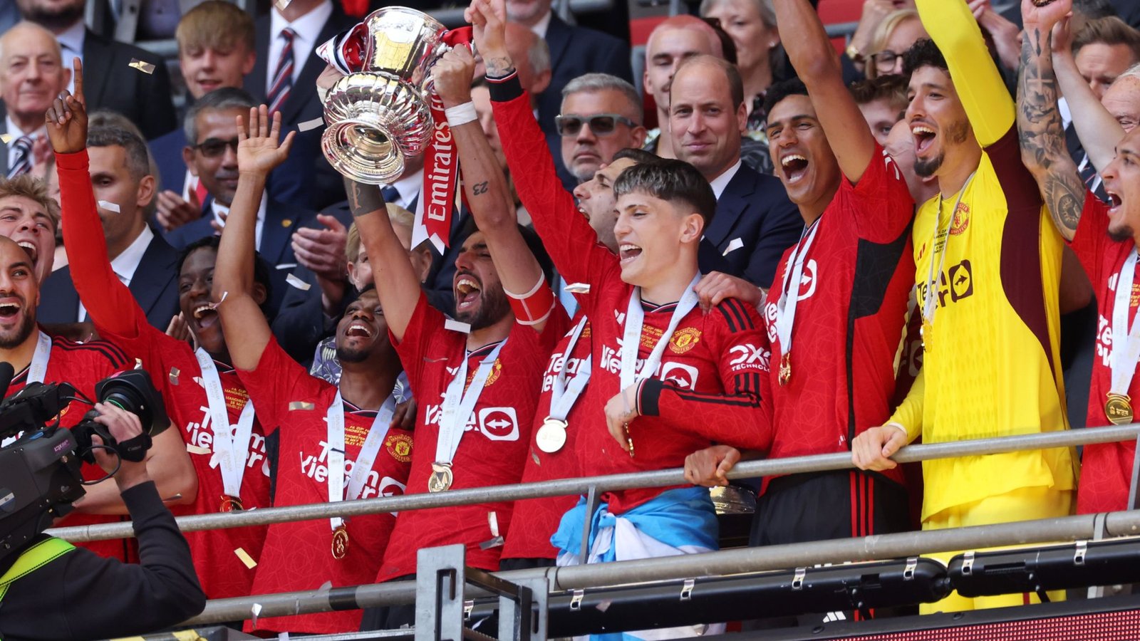 MAN UNITED Bruno Fernandes y Alejandro Garnacho celebrando con el trofeo de la FA Cup 2024 rodeados de la plantilla del Manchester United en Wembley.